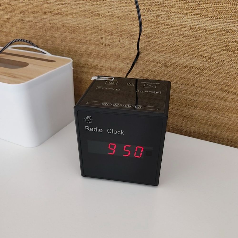 Reloj despertador espía WiFi sobre una mesita de noche